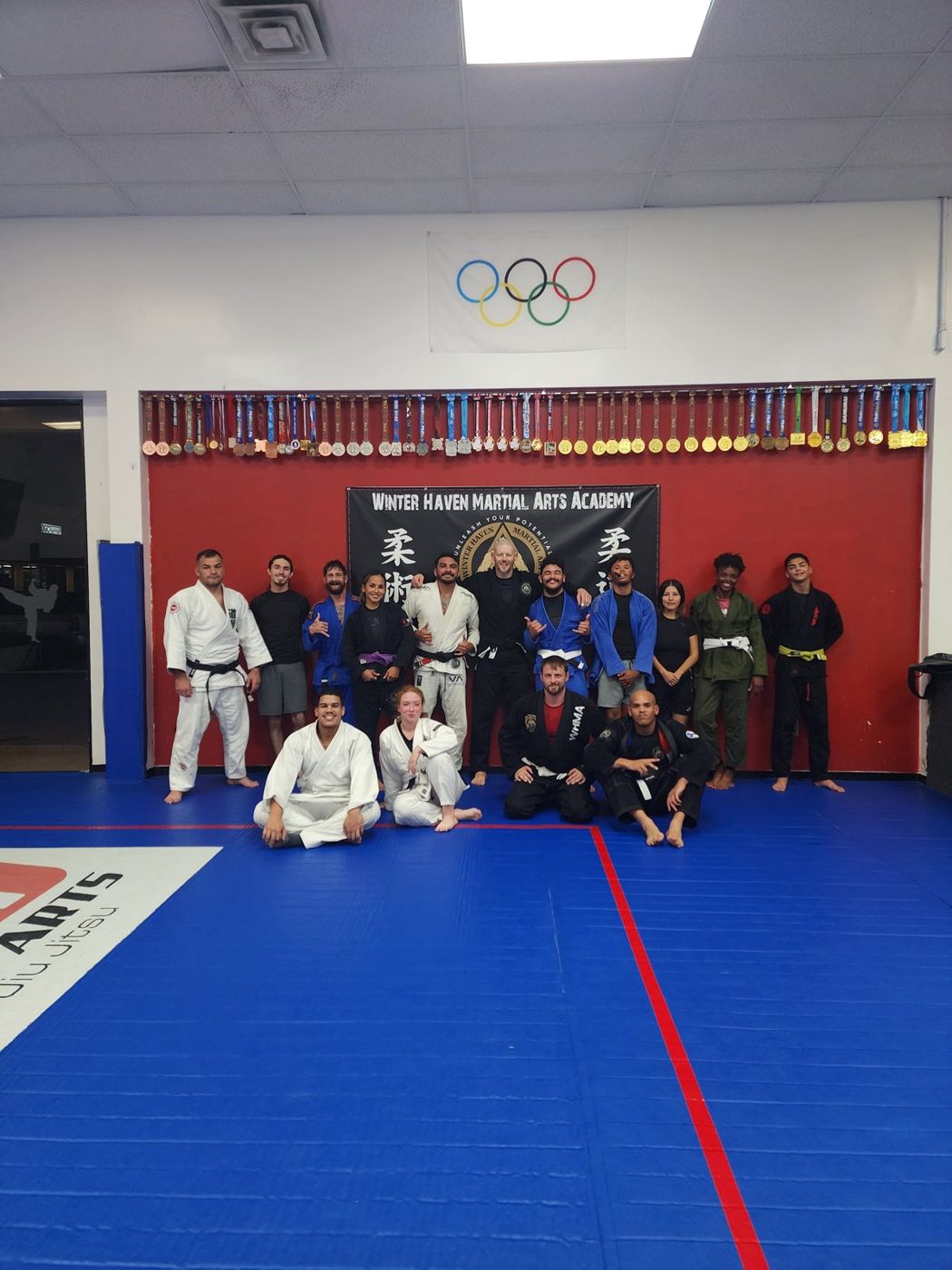 Adult gi Brazilian Jiu-Jitsu class group photo on the mats