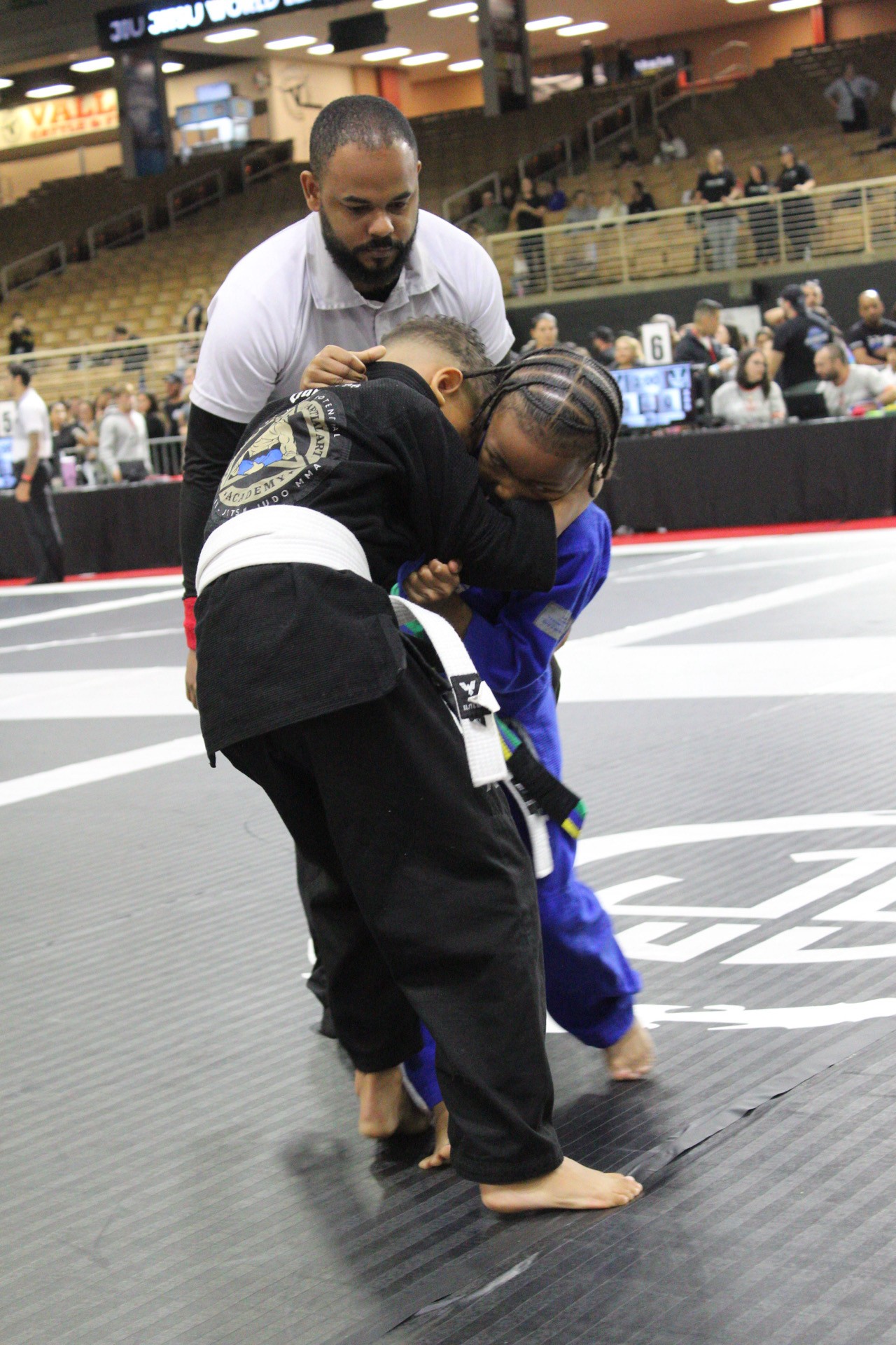 Young Winter Haven competitor working a takedown in a kids gi jiu-jitsu match