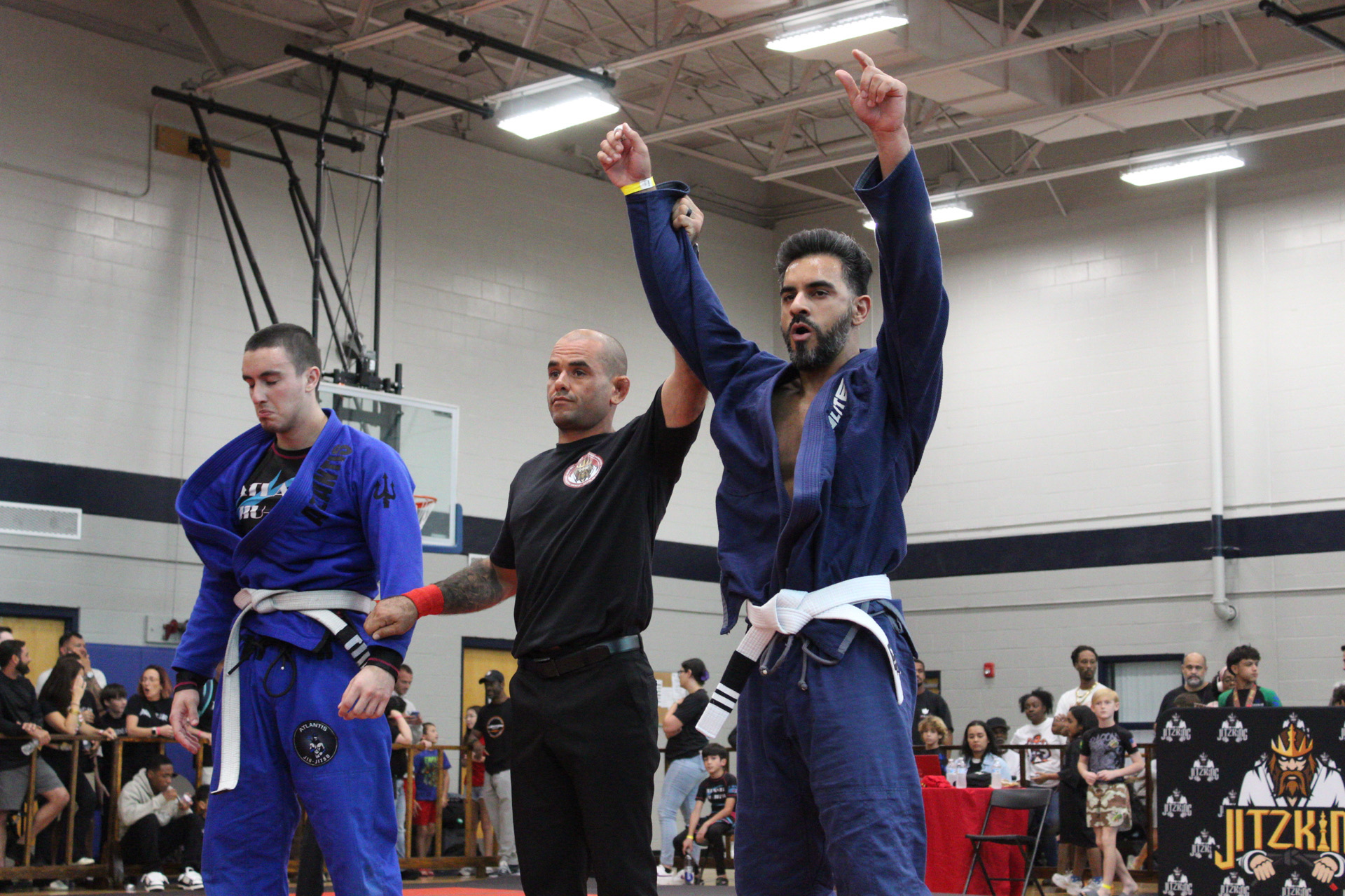 Winter Haven adult jiu-jitsu competitor celebrating a tournament victory as the referee raises his hand