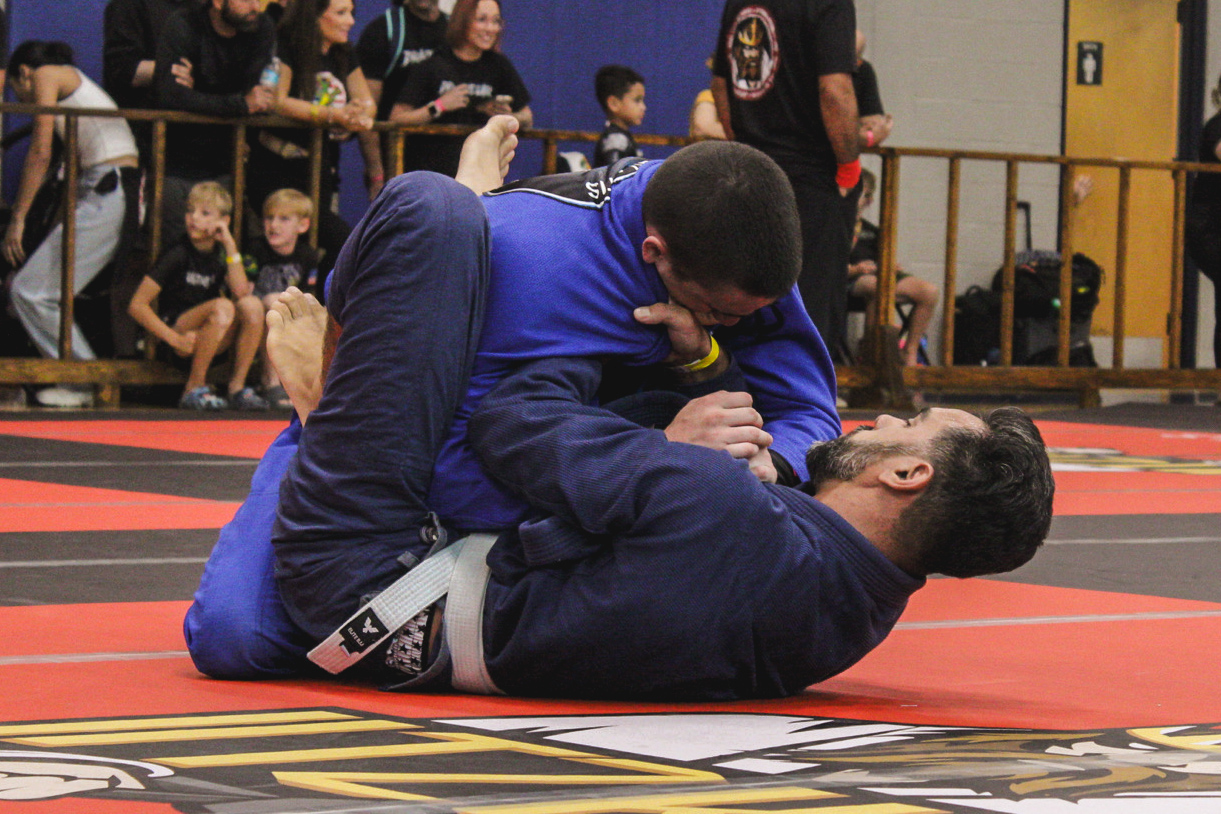 Adult gi Brazilian Jiu-Jitsu match in progress at a Central Florida tournament