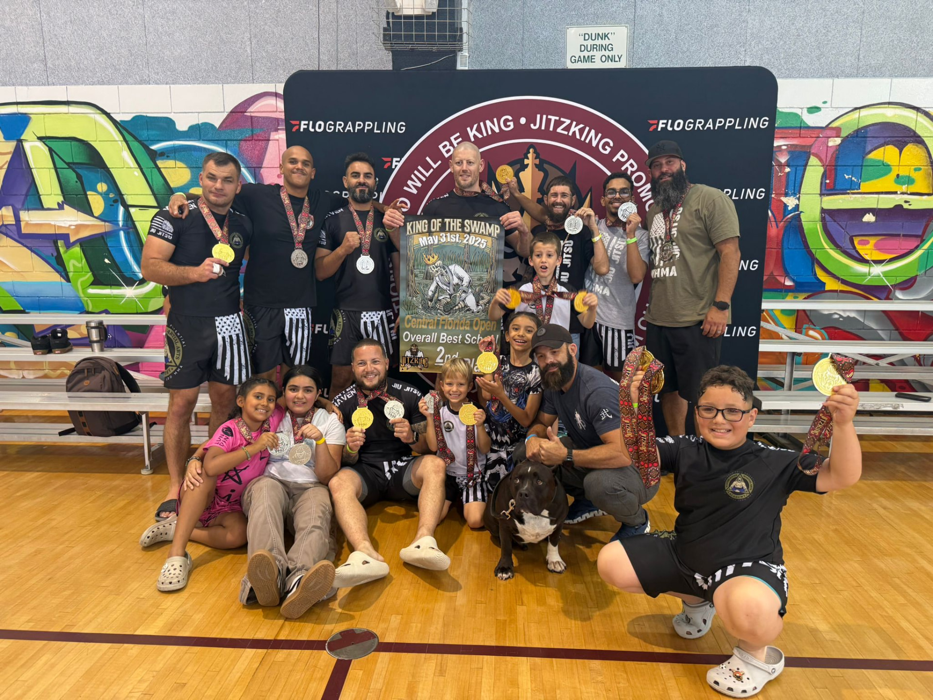 Winter Haven Jiu-Jitsu competition team holding medals and the Central Florida Open second place overall school banner